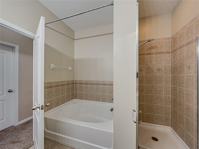 bathroom featuring tile patterned floors, a bath, and a shower stall