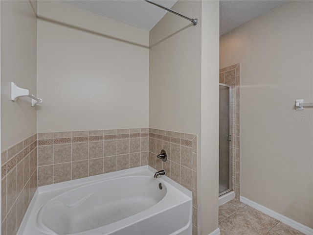 full bathroom featuring tile patterned floors, a textured ceiling, a stall shower, and a bath