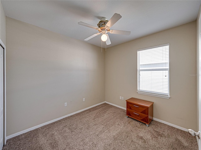 empty room with baseboards, ceiling fan, and carpet floors