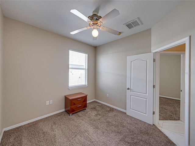 unfurnished room featuring visible vents, carpet flooring, baseboards, and ceiling fan