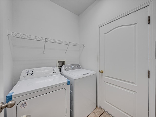 washroom with washing machine and clothes dryer, laundry area, and light tile patterned floors