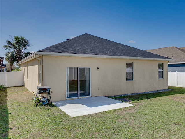 back of house with roof with shingles, a fenced backyard, stucco siding, a patio area, and a lawn