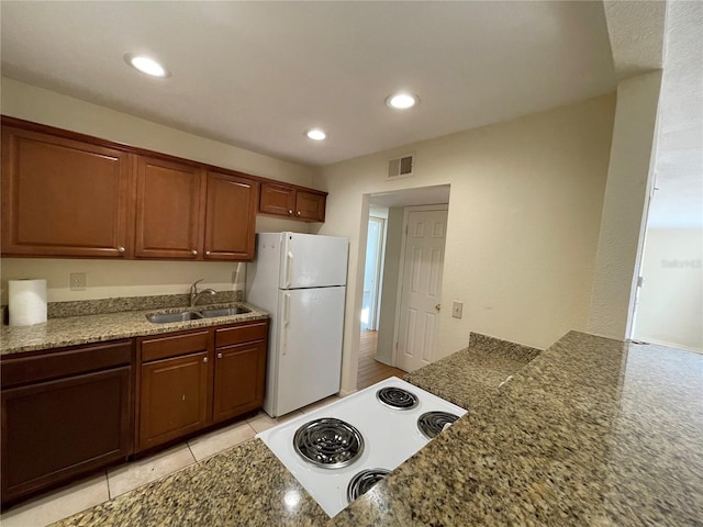 kitchen featuring visible vents, recessed lighting, freestanding refrigerator, a sink, and electric stove