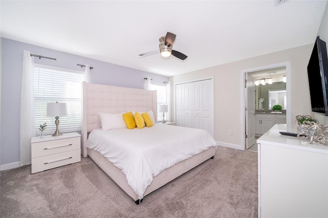 bedroom featuring a closet, light carpet, multiple windows, and baseboards