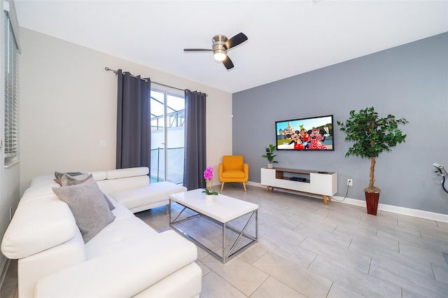 living room with a ceiling fan and baseboards