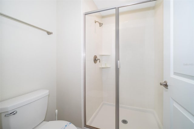 full bath with toilet and a stall shower