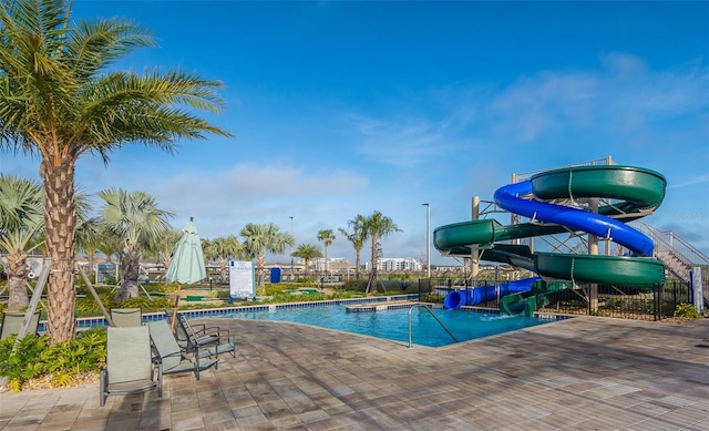 pool with a patio area and a water slide