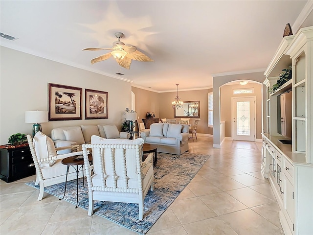 living area featuring visible vents, ornamental molding, ceiling fan with notable chandelier, arched walkways, and light tile patterned flooring