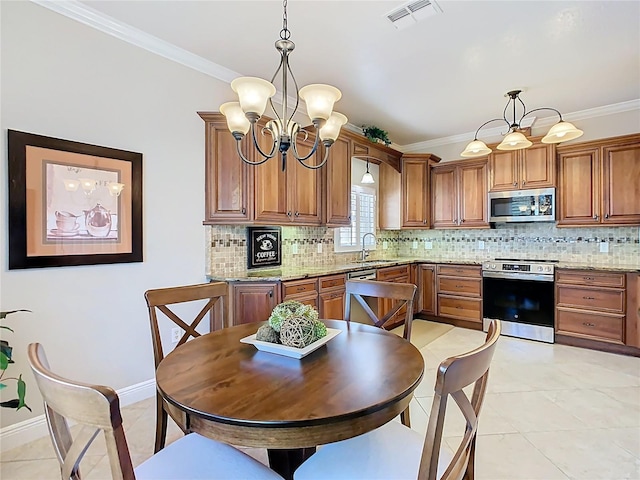 kitchen featuring visible vents, brown cabinets, a notable chandelier, stainless steel appliances, and a sink