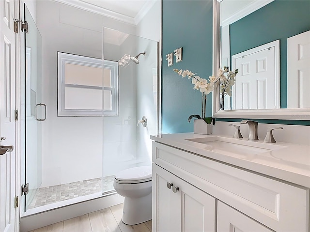 bathroom featuring vanity, toilet, a shower stall, and crown molding