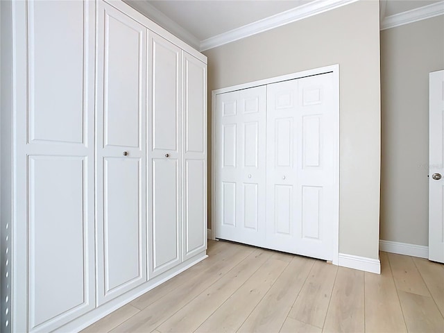 unfurnished bedroom with light wood-style floors, baseboards, a closet, and ornamental molding