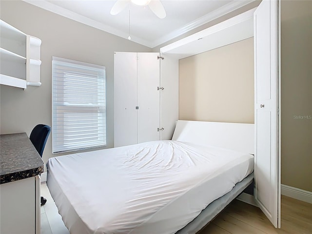 bedroom featuring ceiling fan, baseboards, light wood-style floors, and ornamental molding