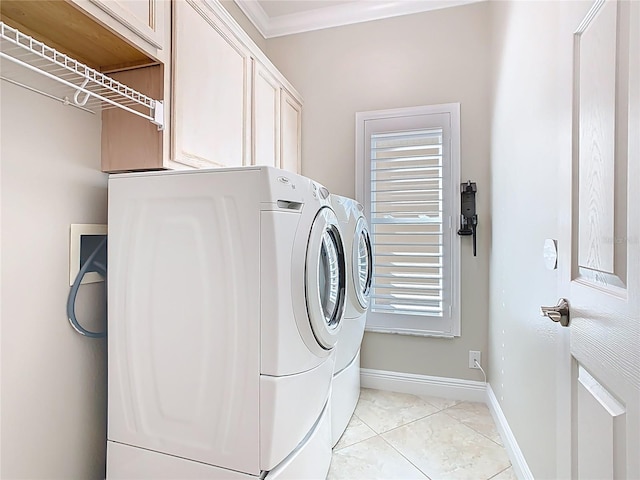 laundry room featuring crown molding, cabinet space, baseboards, and washing machine and clothes dryer