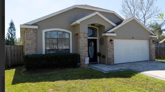 view of front of property with fence, stucco siding, a garage, decorative driveway, and brick siding