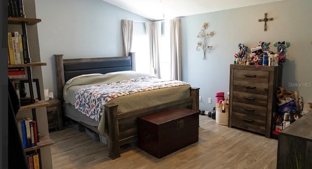 bedroom featuring lofted ceiling and light wood-style flooring