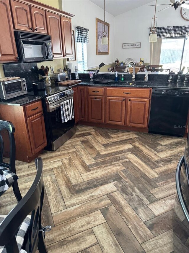 kitchen featuring a toaster, a ceiling fan, black appliances, decorative light fixtures, and a sink