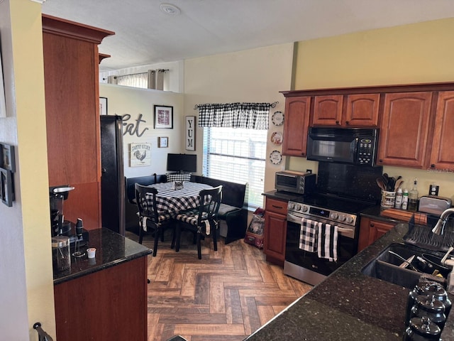 kitchen with dark stone countertops, a sink, black microwave, stainless steel electric range, and a toaster