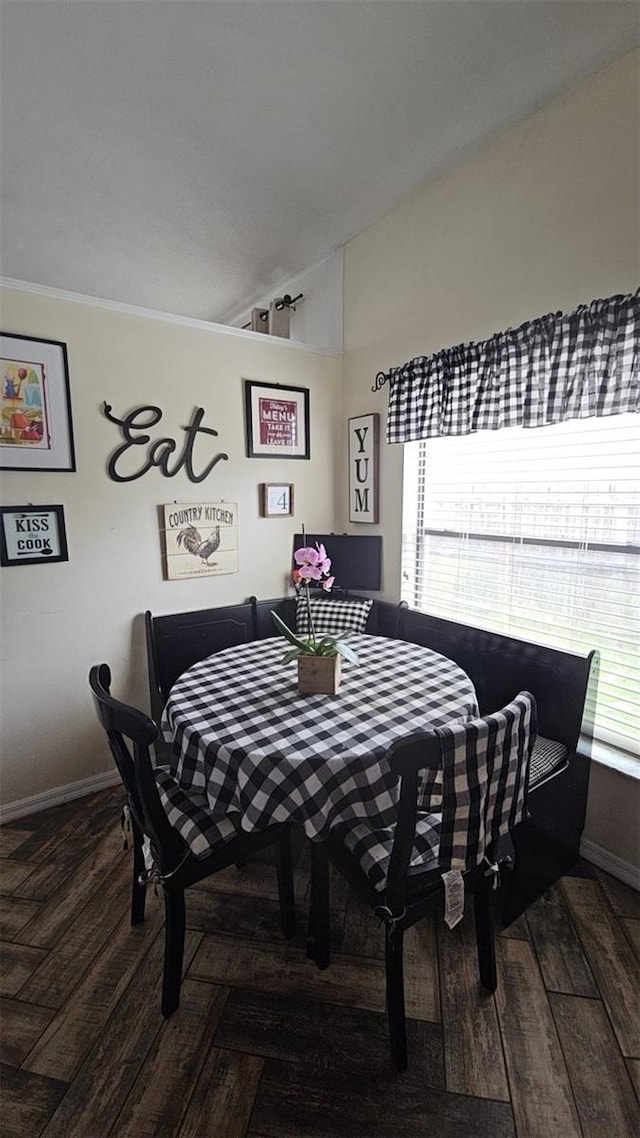 dining space featuring baseboards, vaulted ceiling, and hardwood / wood-style flooring