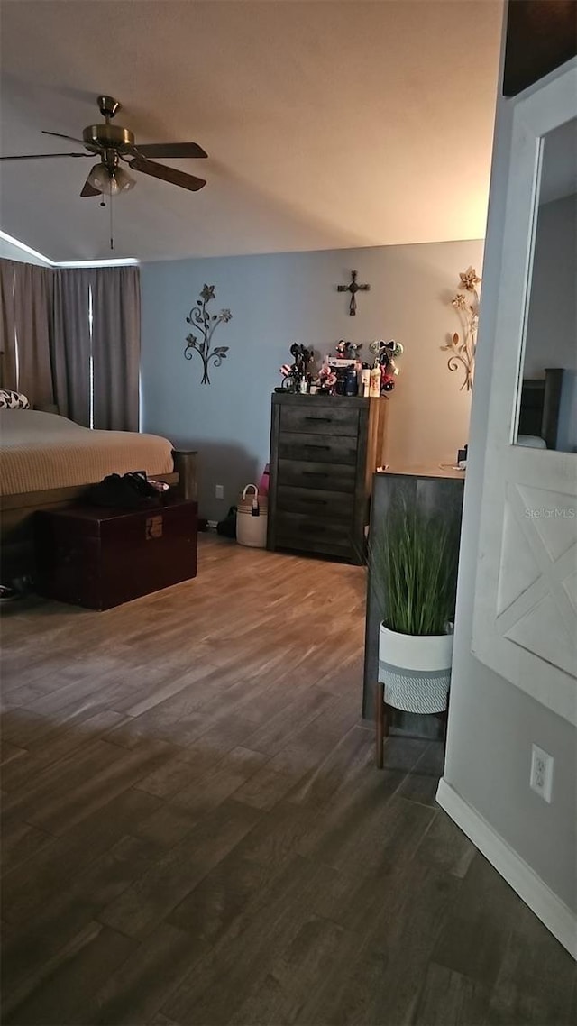 bedroom featuring baseboards, a ceiling fan, and wood finished floors
