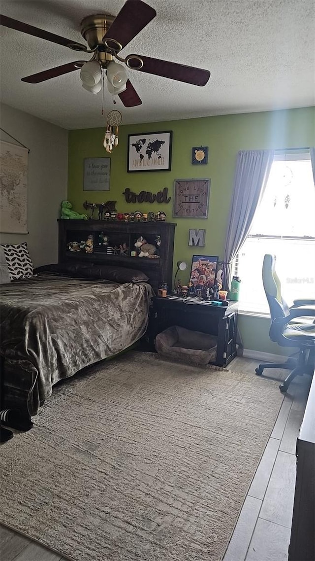 bedroom with a textured ceiling and ceiling fan