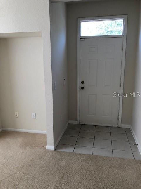 9061 Lee Vista Blvd Unit 1303, Orlando, FL 32829 - foyer featuring baseboards, light colored carpet, and light tile patterned floors
