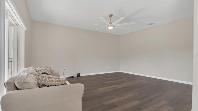 sitting room with dark wood finished floors, baseboards, and ceiling fan