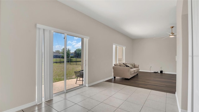 sitting room with light tile patterned floors, baseboards, and ceiling fan