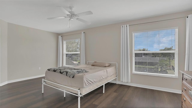 bedroom with baseboards, dark wood-style floors, and a ceiling fan