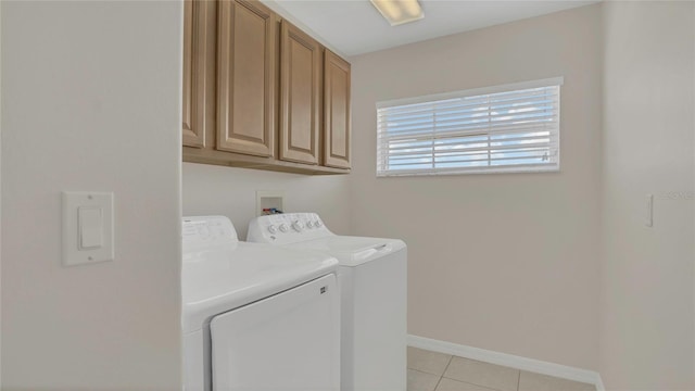 laundry area with washer and clothes dryer, cabinet space, baseboards, and light tile patterned flooring