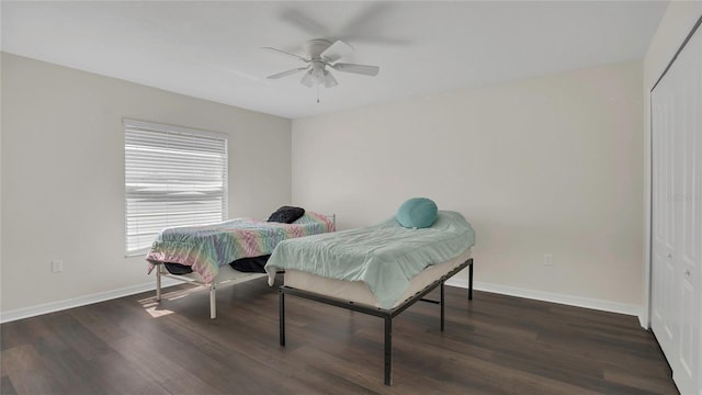 bedroom with wood finished floors, baseboards, a closet, and ceiling fan