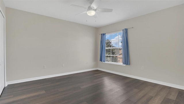 spare room featuring dark wood finished floors, a ceiling fan, and baseboards