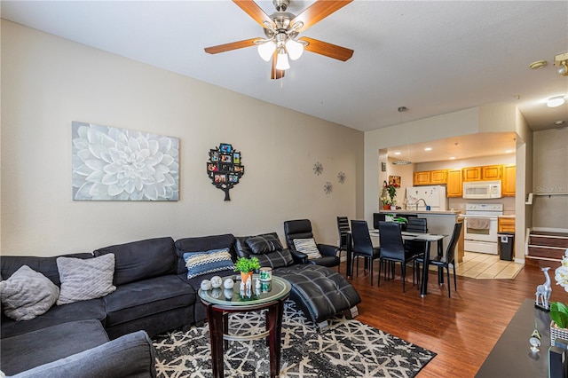 living area with a ceiling fan and light wood-type flooring