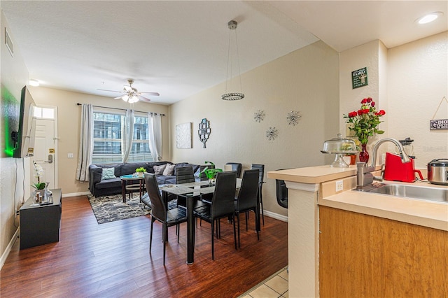 dining area featuring wood finished floors, baseboards, a textured wall, and ceiling fan