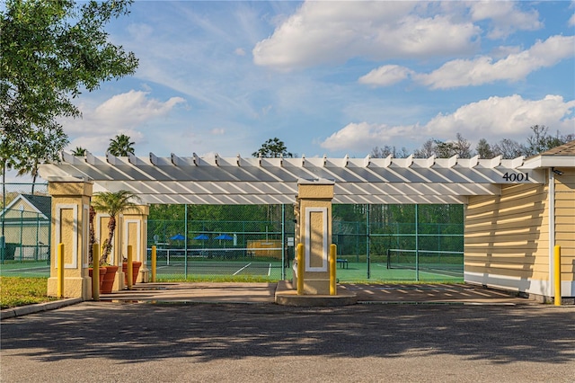 exterior space featuring a tennis court and fence