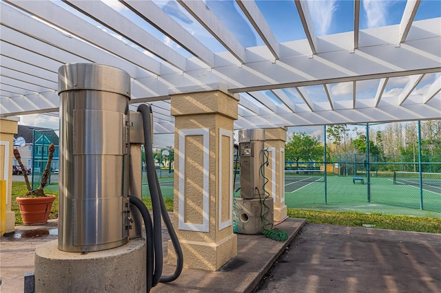 exterior space featuring a tennis court and fence