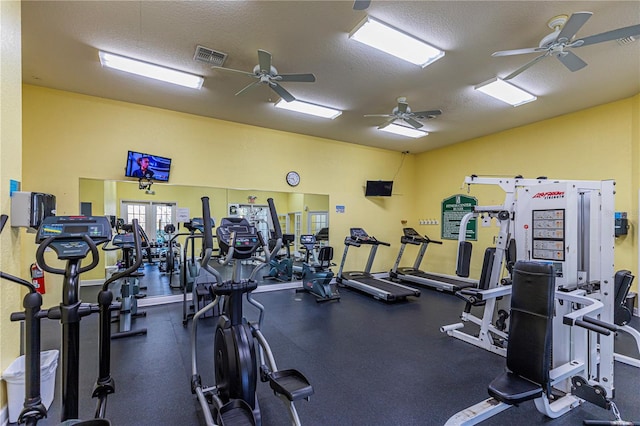 exercise room with visible vents, a textured ceiling, and ceiling fan