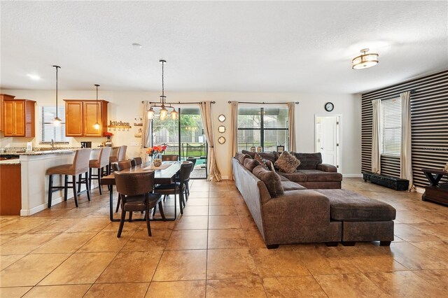 1432 Rolling Fairway Dr, Davenport, FL 33896 - living area featuring light tile patterned floors, baseboards, a chandelier, and a textured ceiling