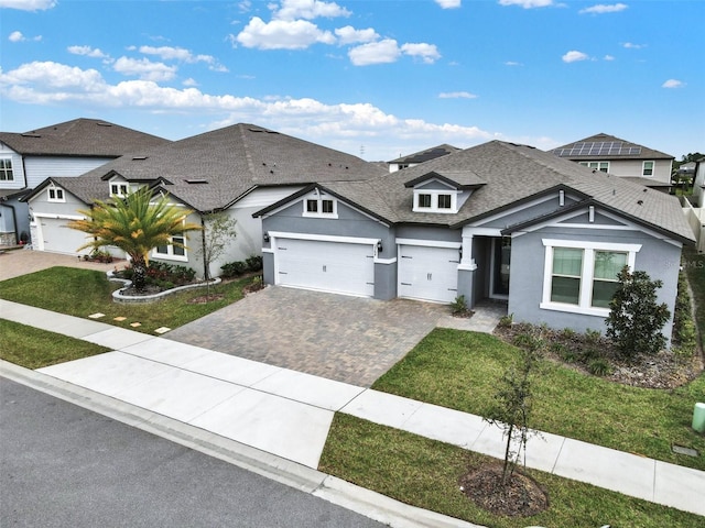 view of front facade featuring stucco siding, driveway, a front lawn, and roof with shingles