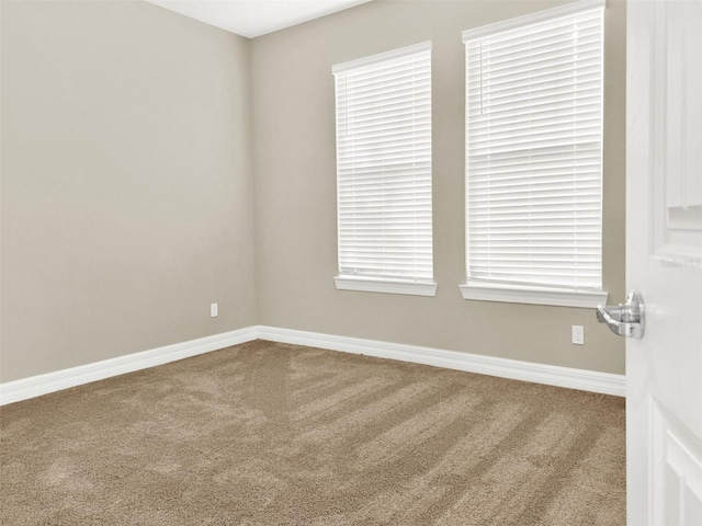 carpeted spare room featuring baseboards