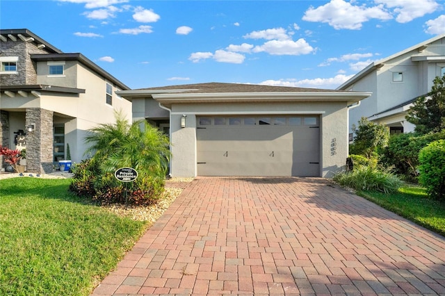 prairie-style home with decorative driveway, an attached garage, and stucco siding