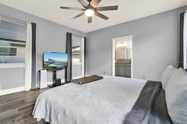 bedroom featuring ceiling fan, ensuite bath, baseboards, and wood finished floors