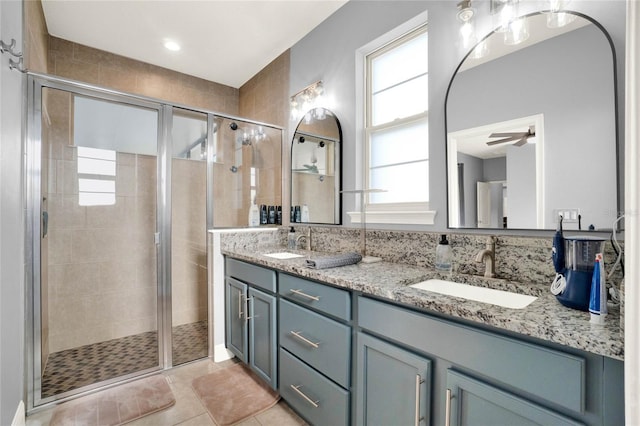 bathroom featuring a sink, double vanity, a shower stall, and tile patterned floors