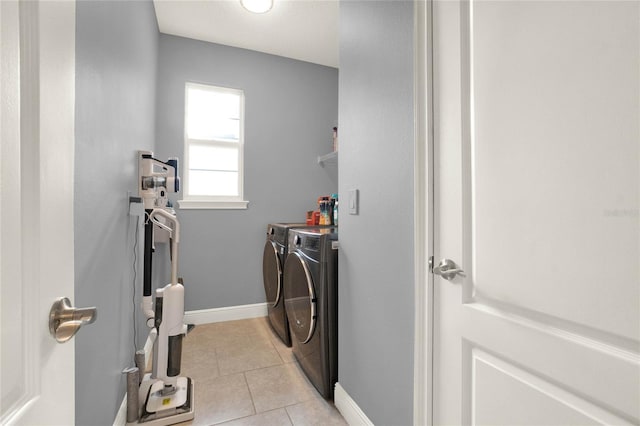 clothes washing area featuring laundry area, light tile patterned floors, baseboards, and independent washer and dryer