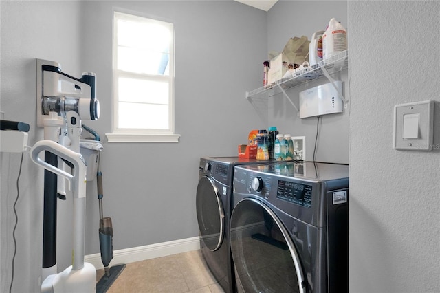 laundry room with tile patterned flooring, laundry area, baseboards, and washer and clothes dryer