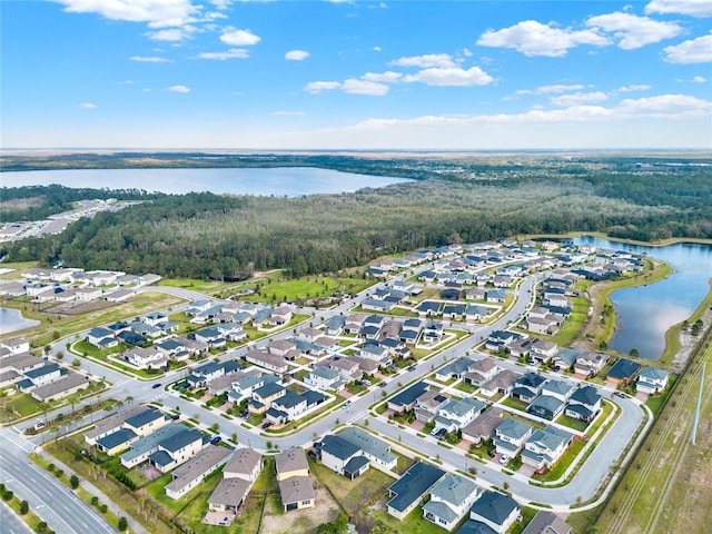 bird's eye view featuring a wooded view, a water view, and a residential view