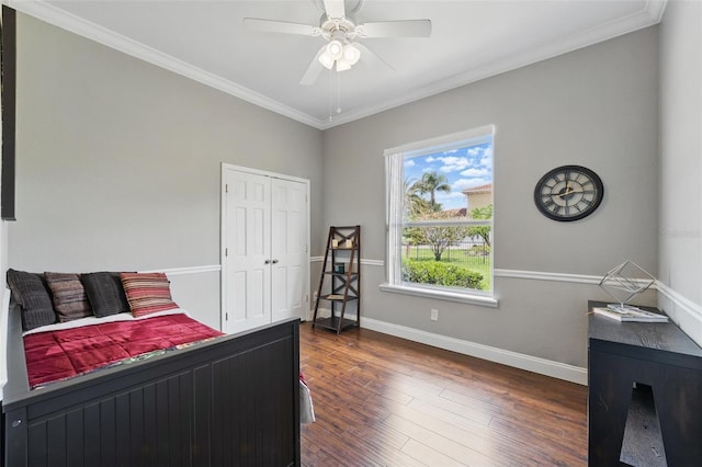 bedroom featuring baseboards, ornamental molding, a closet, and dark wood-style flooring