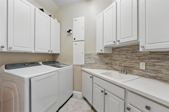 washroom featuring a sink, cabinet space, and washing machine and clothes dryer