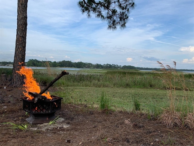 view of yard featuring a water view and a fire pit