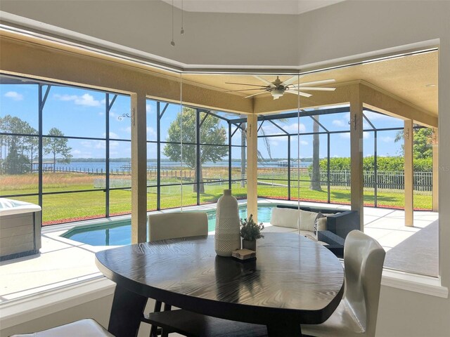 sunroom featuring a water view
