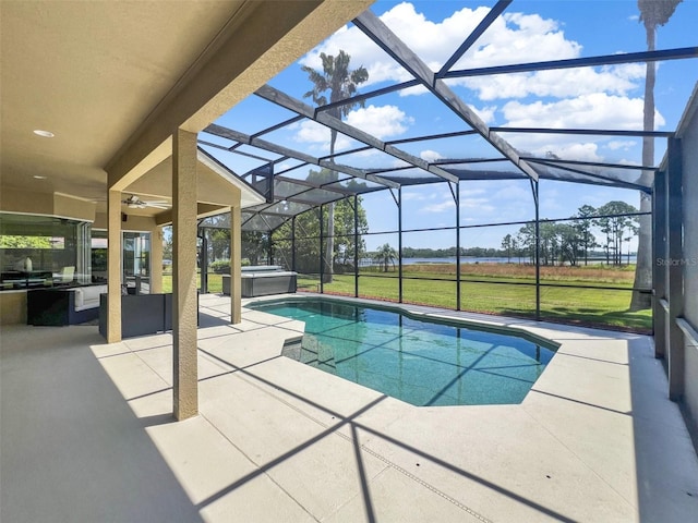 swimming pool with an outdoor hot tub, a patio, ceiling fan, and a lanai